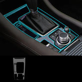 Car center console with neon blue trim accents and sleek black leather gear shift.
