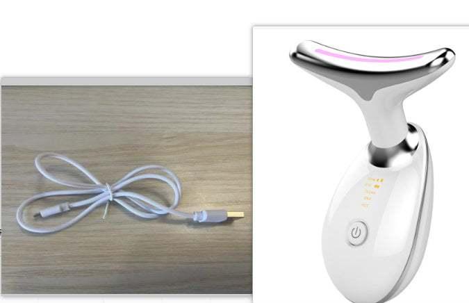 White handheld facial massager with silver head and LED light, includes USB charging cable