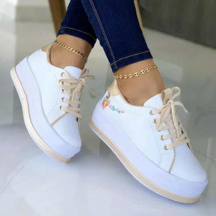 White platform sneakers with beige accents, floral embroidery, casual fit, worn with skinny jeans
