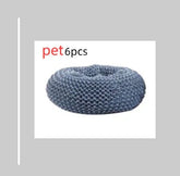 Round grey textured pet bed, soft plush material, donut shape, cozy fit.