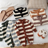 Striped fuzzy knit baby rompers and cardigans in earthy tones on a bed, winter clothing set