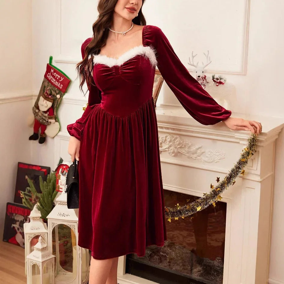 Woman wearing a red velvet long-sleeve midi dress with white fur trim, festive setting.