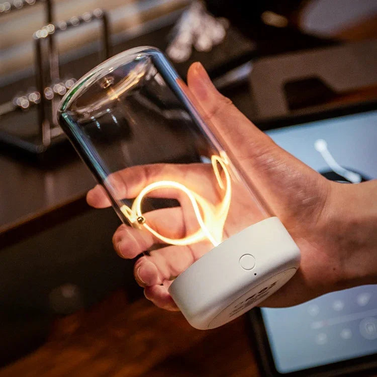 Hand holding modern glass LED lamp with spiral filament and white base indoors