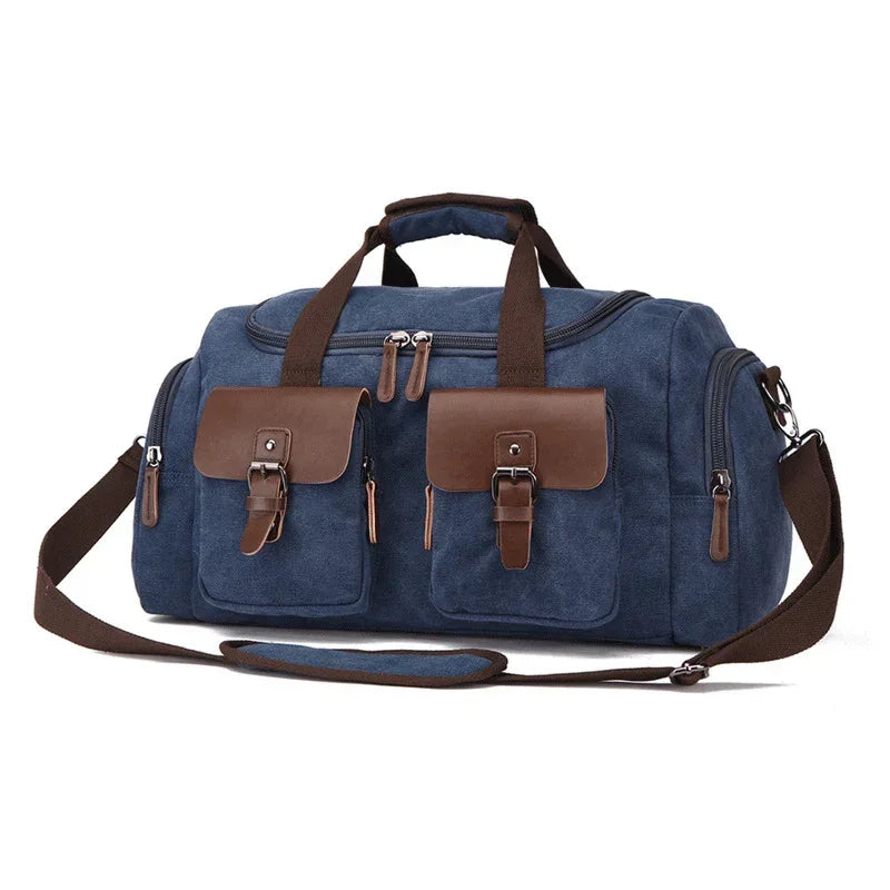 Blue canvas duffle bag with brown leather straps and pockets, adjustable shoulder strap