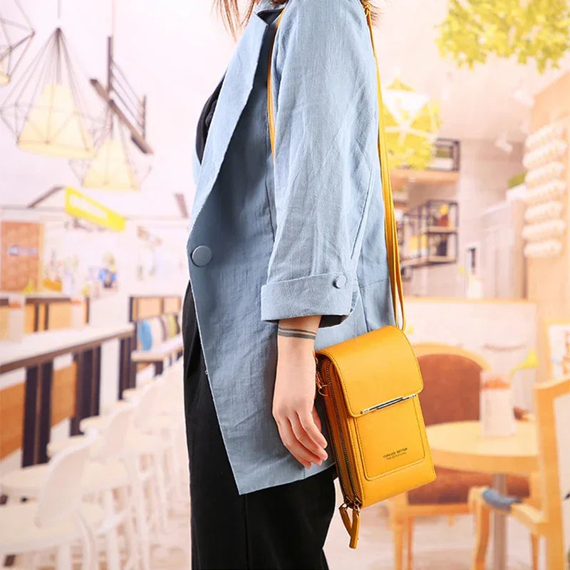 Light blue oversized blazer with rolled sleeves, paired with black pants and a yellow crossbody bag.