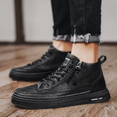 Black faux leather high-top sneakers with side zipper, lace-up front, and thick sole, styled with distressed slim-fit jeans.