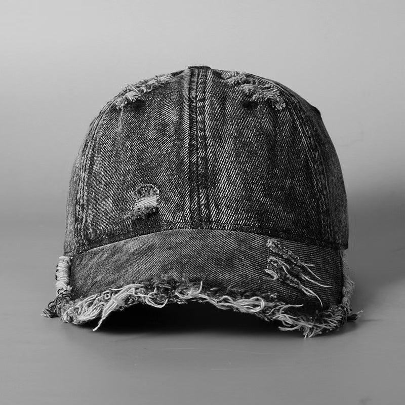 Distressed black denim baseball cap with frayed edges and relaxed streetwear style.