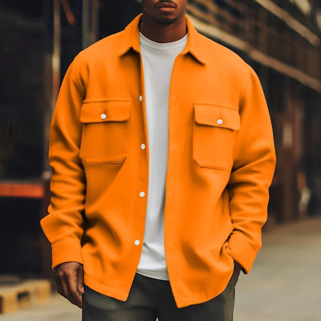 Man wearing oversized orange button-up shirt jacket with chest pockets, casual street style.