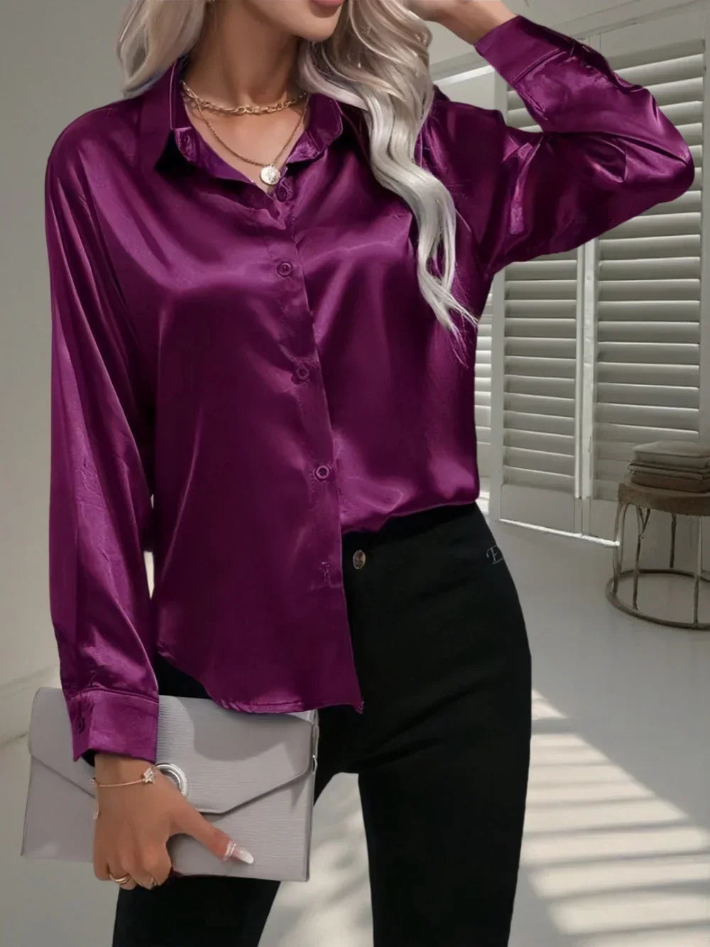 Woman wearing a purple satin button-up shirt with long sleeves and black fitted pants