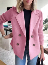 Woman wearing a pink double-breasted wool blazer with ribbed knit sleeves, paired with jeans
