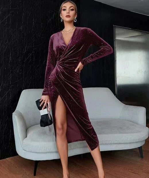 Woman in a velvet burgundy wrap dress with long sleeves and a thigh-high slit