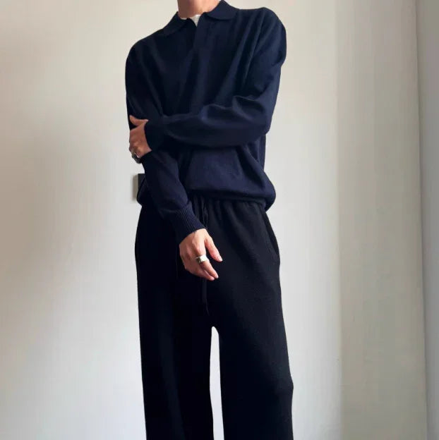 Person wearing loose-fit black knit polo sweater and wide-leg drawstring pants