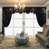 Elegant living room with dark velvet draped curtains, tufted beige sofas, ornate coffee table, and chandelier