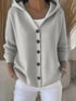 Light gray knit button-up hoodie cardigan with relaxed fit and long sleeves, paired with white pants
