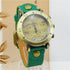 Vintage style watch with green leather strap, brass case, and musical notes dial.