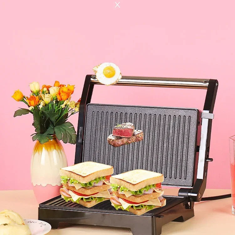 Double-decker grilled sandwiches with lettuce and deli meat on a black panini press, pink background.