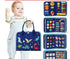 Toddler wearing light blue overalls and striped shirt, holding a navy blue dinosaur-printed educational felt activity book.