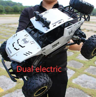 Large off-road RC car with white metal body, black details, rugged tires, outdoors