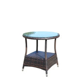 Round glass top outdoor side table with brown rattan frame and lower storage shelf