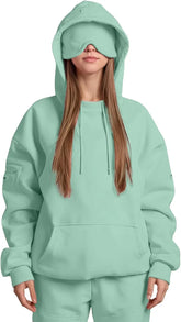 Woman wearing oversized mint green hoodie and sweatpants with matching eye mask, streetwear style