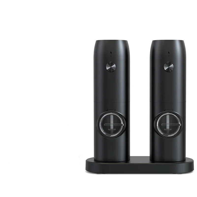 Pair of sleek black automatic salt and pepper grinders with adjustable settings on charging base