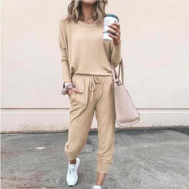 Woman in beige long sleeve jogger set with drawstring waist, relaxed fit, and white sneakers