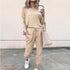 Woman in beige long sleeve jogger set with drawstring waist, relaxed fit, and white sneakers