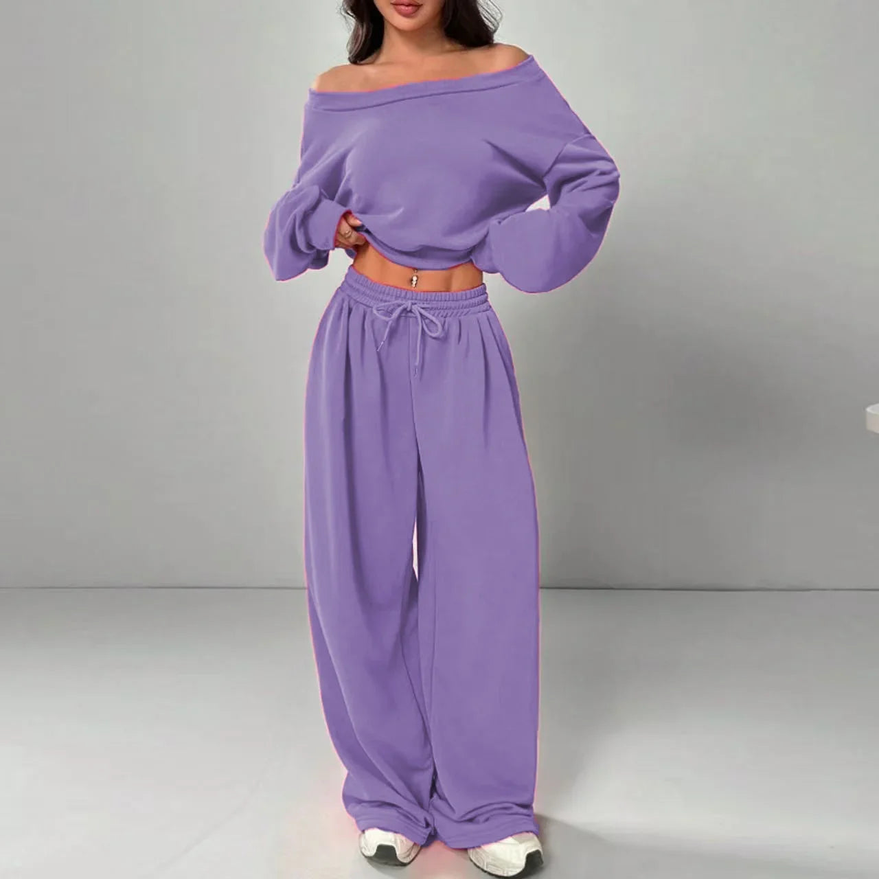 Woman wearing loose fit lavender off-shoulder sweatshirt and wide leg jogger pants set