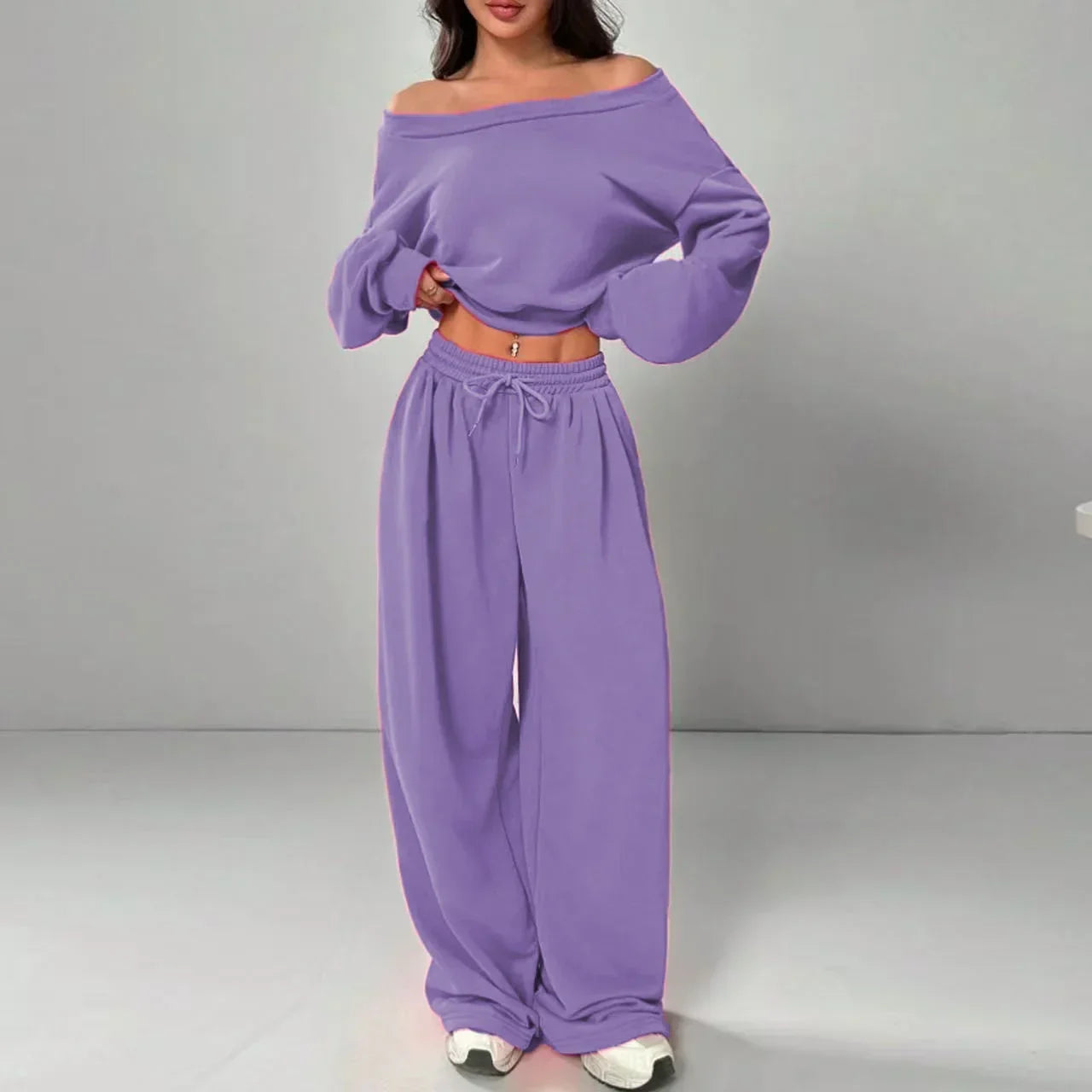 Woman wearing loose fit lavender off-shoulder sweatshirt and wide leg jogger pants set