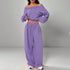Woman wearing loose fit lavender off-shoulder sweatshirt and wide leg jogger pants set