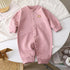 Pink striped baby romper with snap buttons, long sleeves, and soft cotton material.