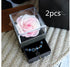 Light pink preserved rose in clear acrylic box with velvet jewelry drawer containing blue charm bracelets