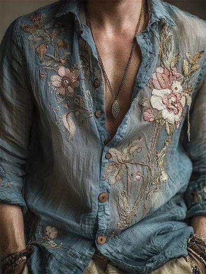 Sheer blue floral embroidered button-up shirt with relaxed fit, lightweight fabric, and rolled sleeves.