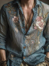 Sheer blue floral embroidered button-up shirt with relaxed fit, lightweight fabric, and rolled sleeves.
