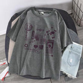 Oversized grey graphic t-shirt with abstract purple prints, paired with light denim shorts