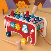 Colorful wooden toddler toy with gears, mallets, and pop-up animal pegs shaped like a bus