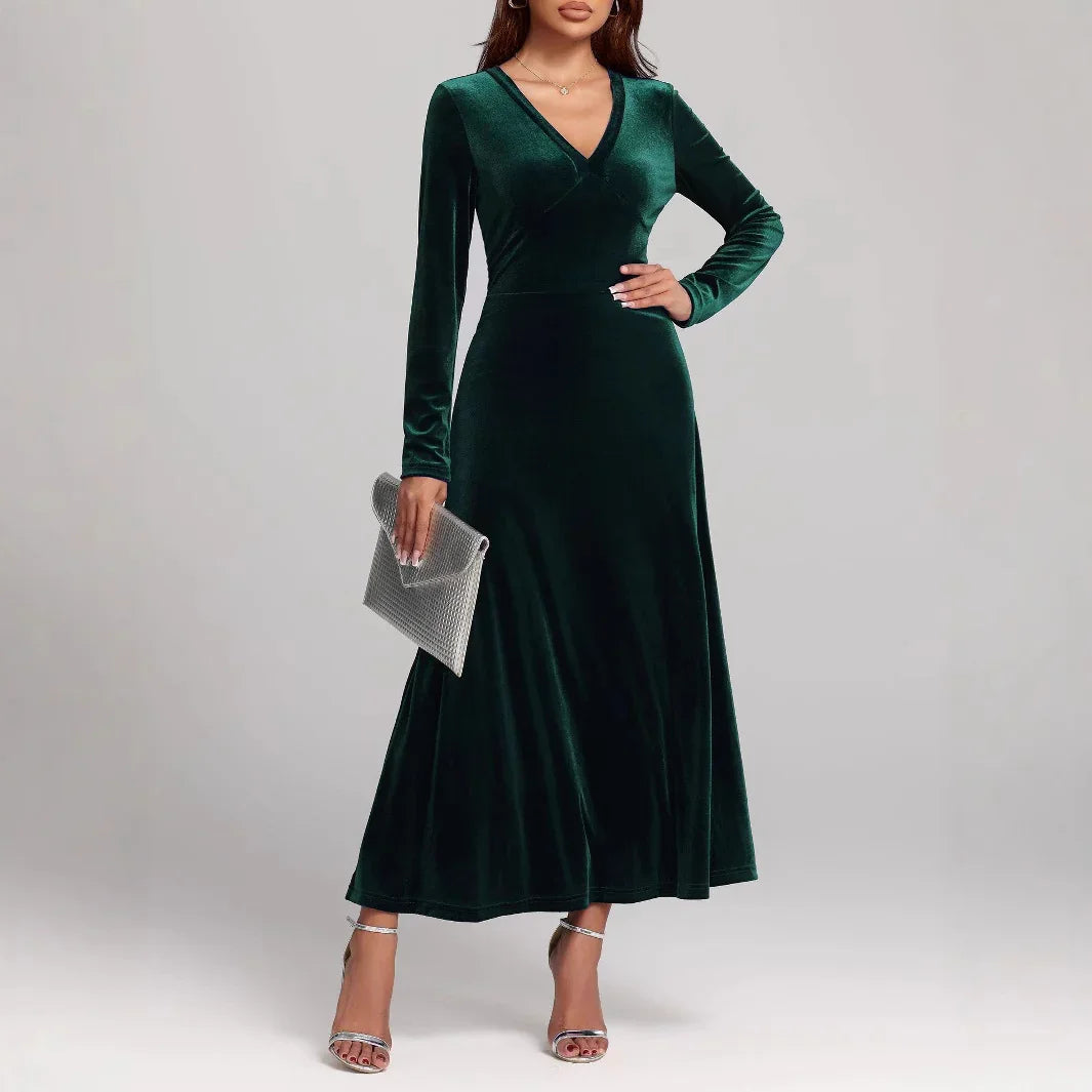 Woman wearing long sleeve dark green velvet maxi dress, v-neck, fitted waist, elegant fit