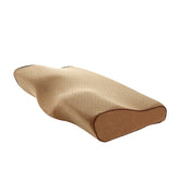 Contoured beige memory foam pillow with ergonomic shape and perforated breathable cover