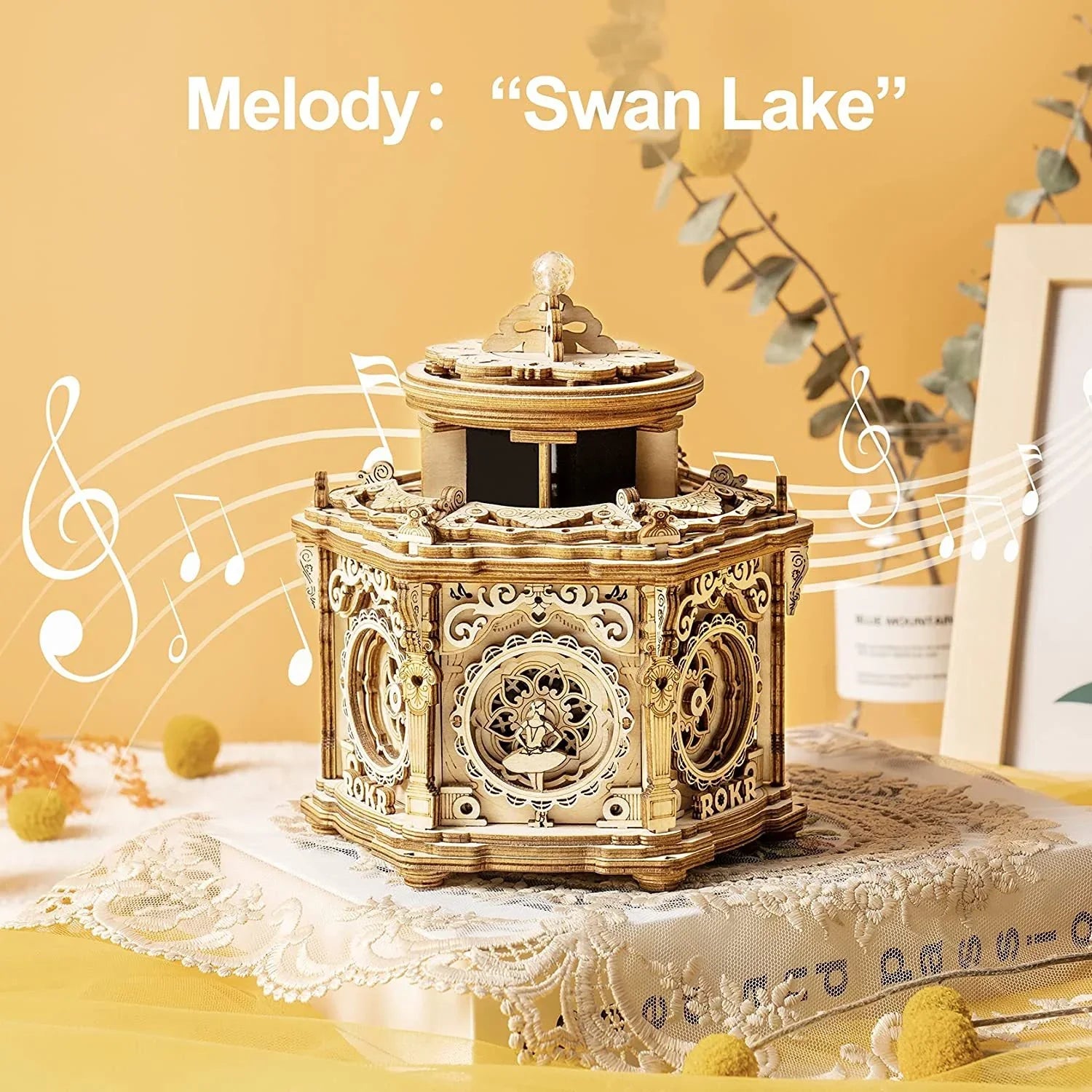 Intricate wooden music box featuring Swan Lake melody, ornate carved details, decorative lace setting.
