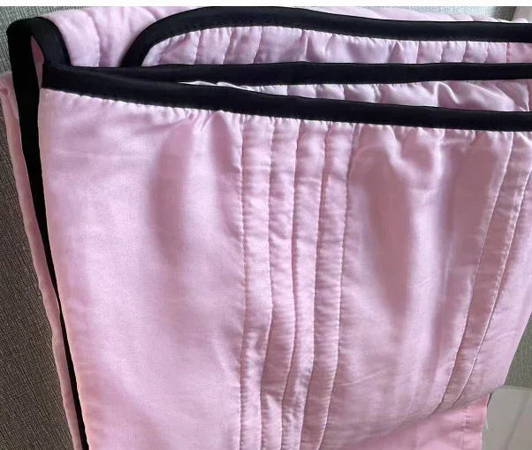 Light pink quilted satin pants with black trim, relaxed fit, modern streetwear style