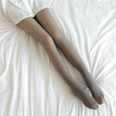 Sheer gray tights with a slim fit, worn with a white skirt, on a bed with white sheets.