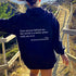 Woman outdoors in oversized black hoodie with positive quote, relaxed fit, walking on scenic trail