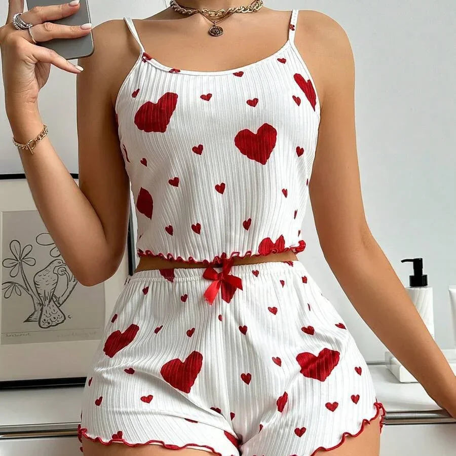 White ribbed camisole and shorts pajama set with red heart print, slim fit, ruffle trim.