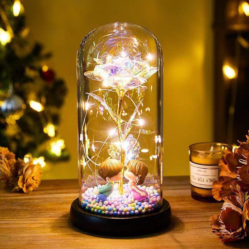 Glass dome with LED rose flower, two figurines, pastel beads, and warm ambient lighting