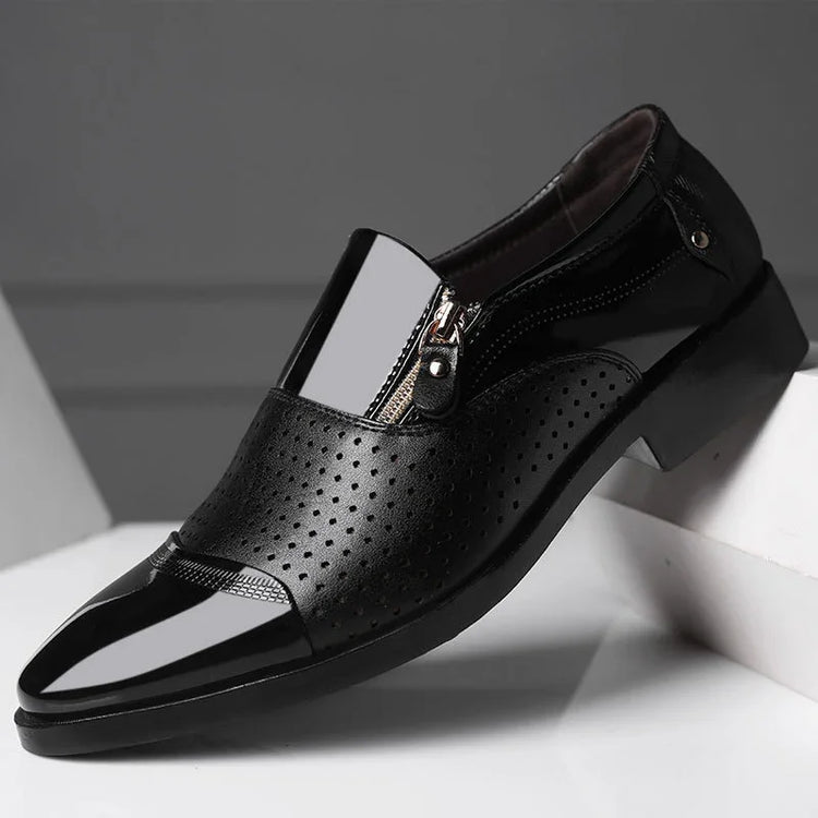Black glossy formal shoe with perforated leather, side zipper, and sleek pointed toe.