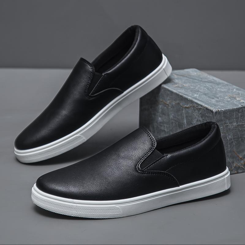Black slip-on sneakers with white soles, faux leather material, minimalist streetwear style