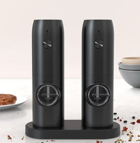 Set of two black electric salt and pepper grinders with modern matte finish on kitchen counter