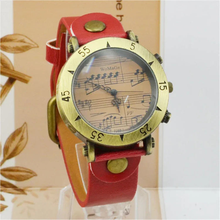 Vintage-inspired watch with red leather strap and musical note dial, bold brass accents.