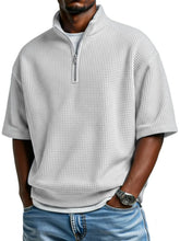Man wearing a light gray waffle knit half-zip pullover with short sleeves and relaxed fit.