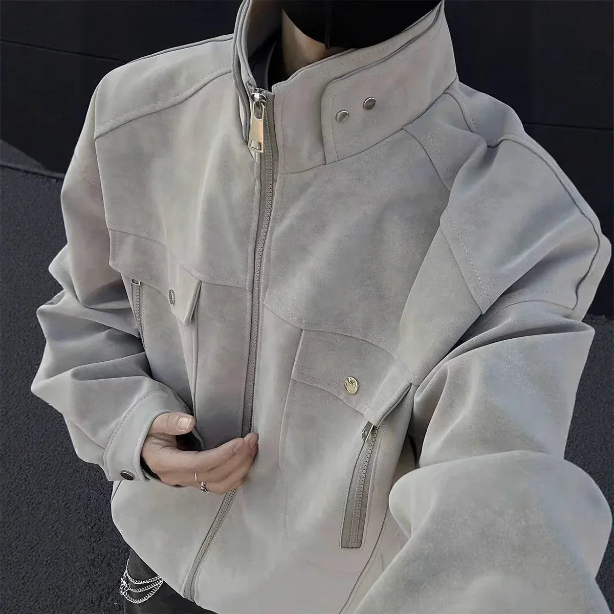 Oversized light grey suede jacket with high collar, chest pockets, and zipper closure, streetwear style